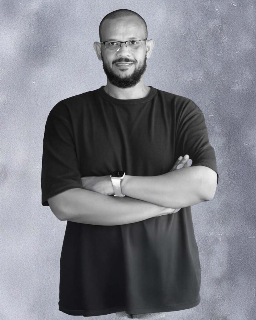 Khalid Mohamed, Managing Director of ITD Innovation, seated at a modern workspace, reviewing IT project designs on a digital screen, representing leadership in technology and creative innovation.