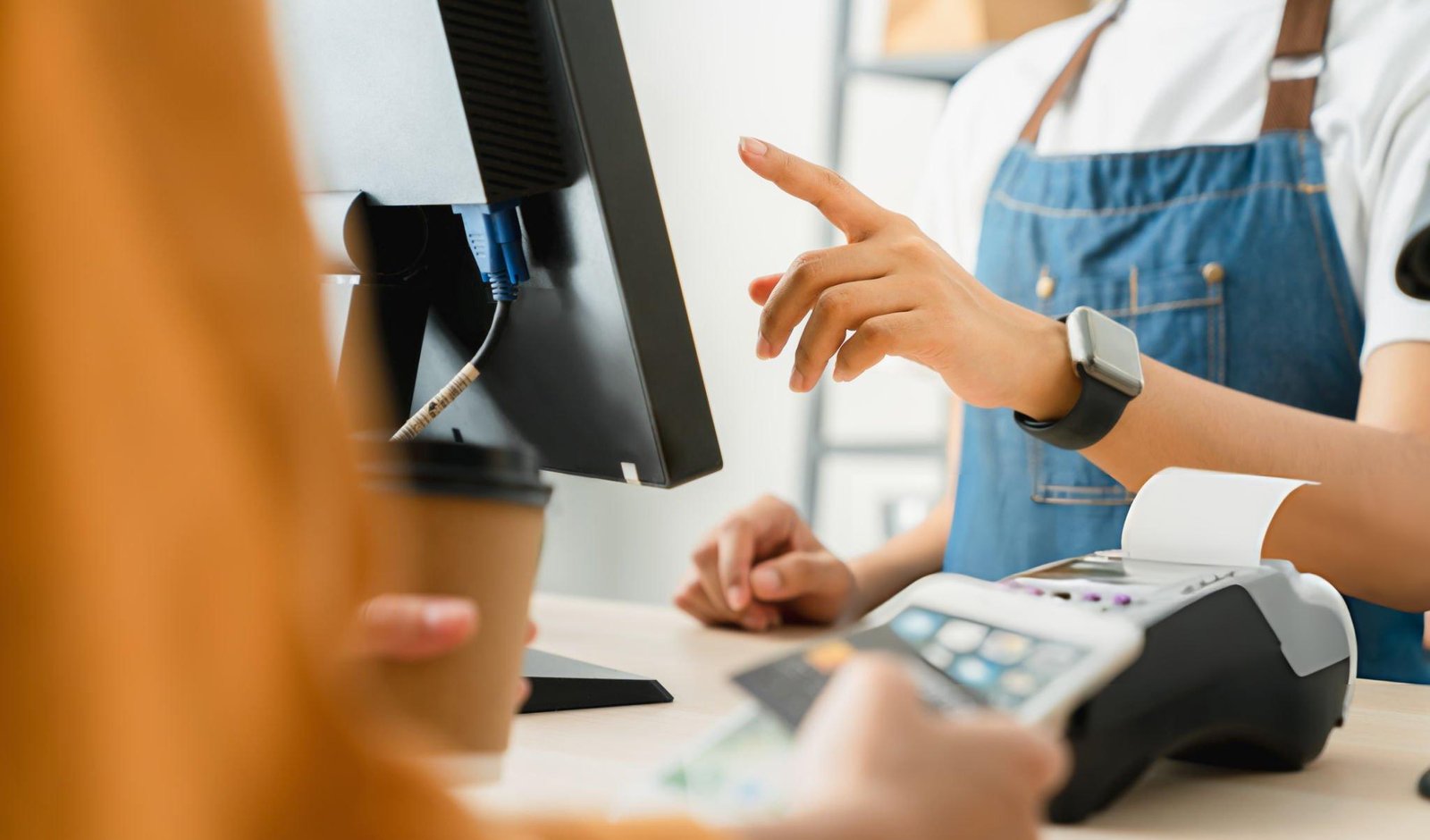 Female cashier using a POS system while assisting a customer in a supermarket for ITD INNOVATION DUBAI.